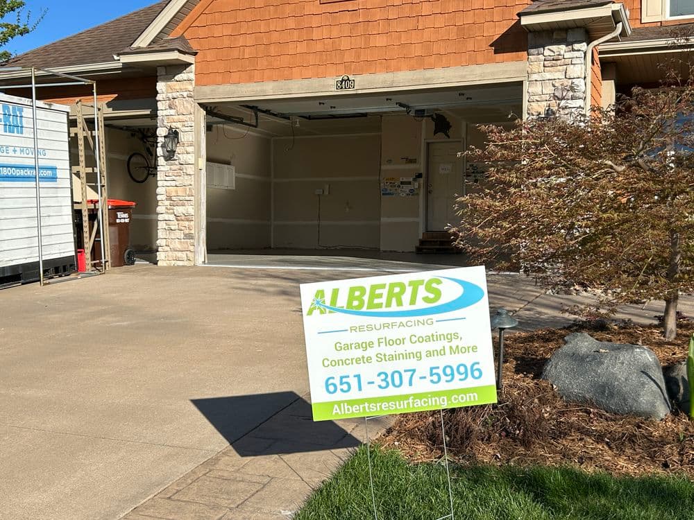 Garage with sign promoting Albert's Resurfacing services for concrete and floor coatings.