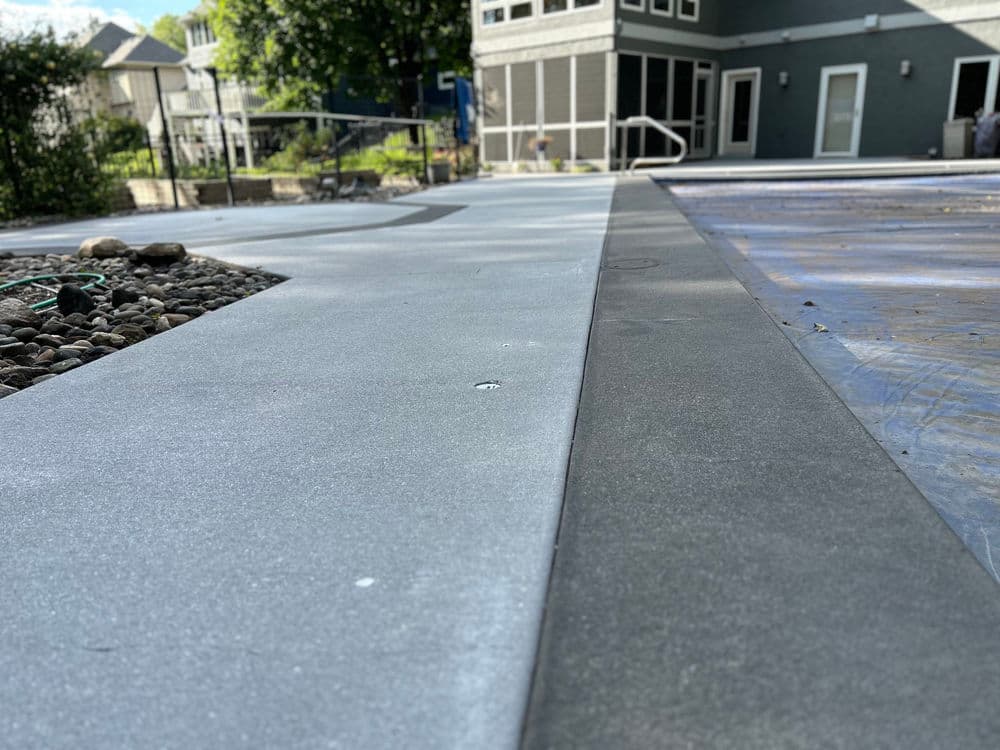 Freshly poured concrete patio with a sleek finish adjacent to a modern home.